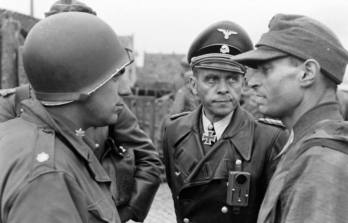 El brigadeführer Jurgen Wagner, comandante de la 23 división de granaderos panzer de la SS “Nederland” rindiéndose ante el Tte coronel Leroy E Frazier en el río Elba, cerca de Tangermünde. 6 de mayo de 1945.