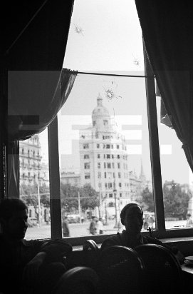 This a great shot by Cologne photographer Juan Guzmán. 26 July 1936. Inside restaurant of Hotel Colon taken over PSUC (communist) militia after the defeat of coup in Barcelona. Bullet holes in the window. Across Plaça Catalunya the Telephone Exchange controlled by anarchist CNT.