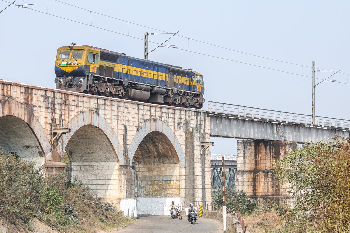 Lone VISHAKAPATANAM WDG-4D covered in dust and faded colors crossing Majhigouri Rayagada railway bridge