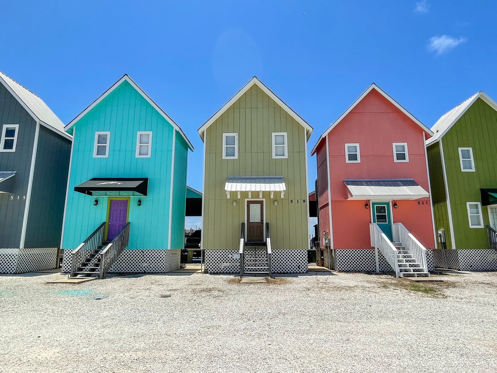 How cute are these colorful and skinny houses known as the Bird Houses? Read the full article: 15 Best Things To Do On Dauphin Island, Alabama ▸ bit.ly/3C4x01m #DauphinIsland #Alabama #GulfCoast #travel #islands