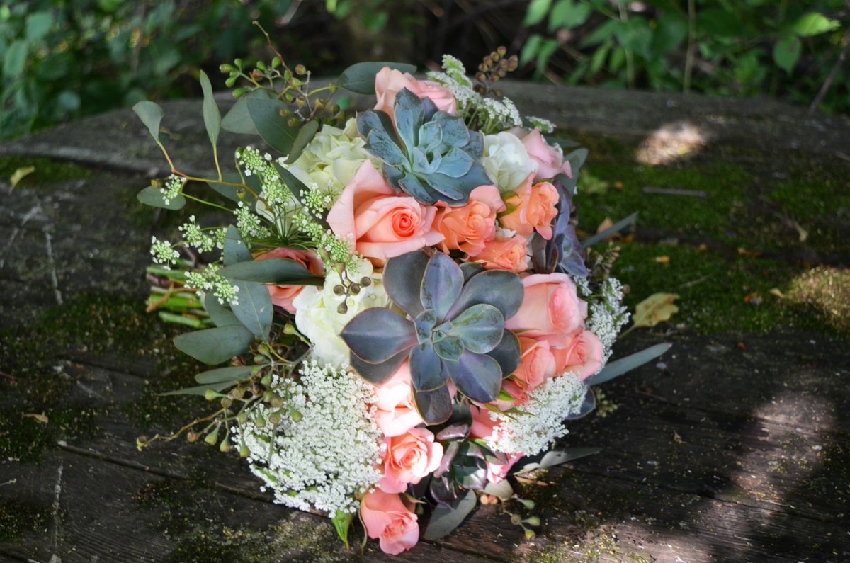 💐 Check out this stunning bridal bouquet featuring a mix of gorgeous succulents, delicate peachy pink roses, and a variety of textures in the filler. What do you think of this unique floral arrangement? Let us know in the comments below! #bridalbouquet #weddingflowers