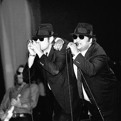 Dan Aykroyd and John Belushi with Steve Cropper performing with The Blues Brothers at the Palladium in New York City, 1980. Photo by ©Ebet Roberts