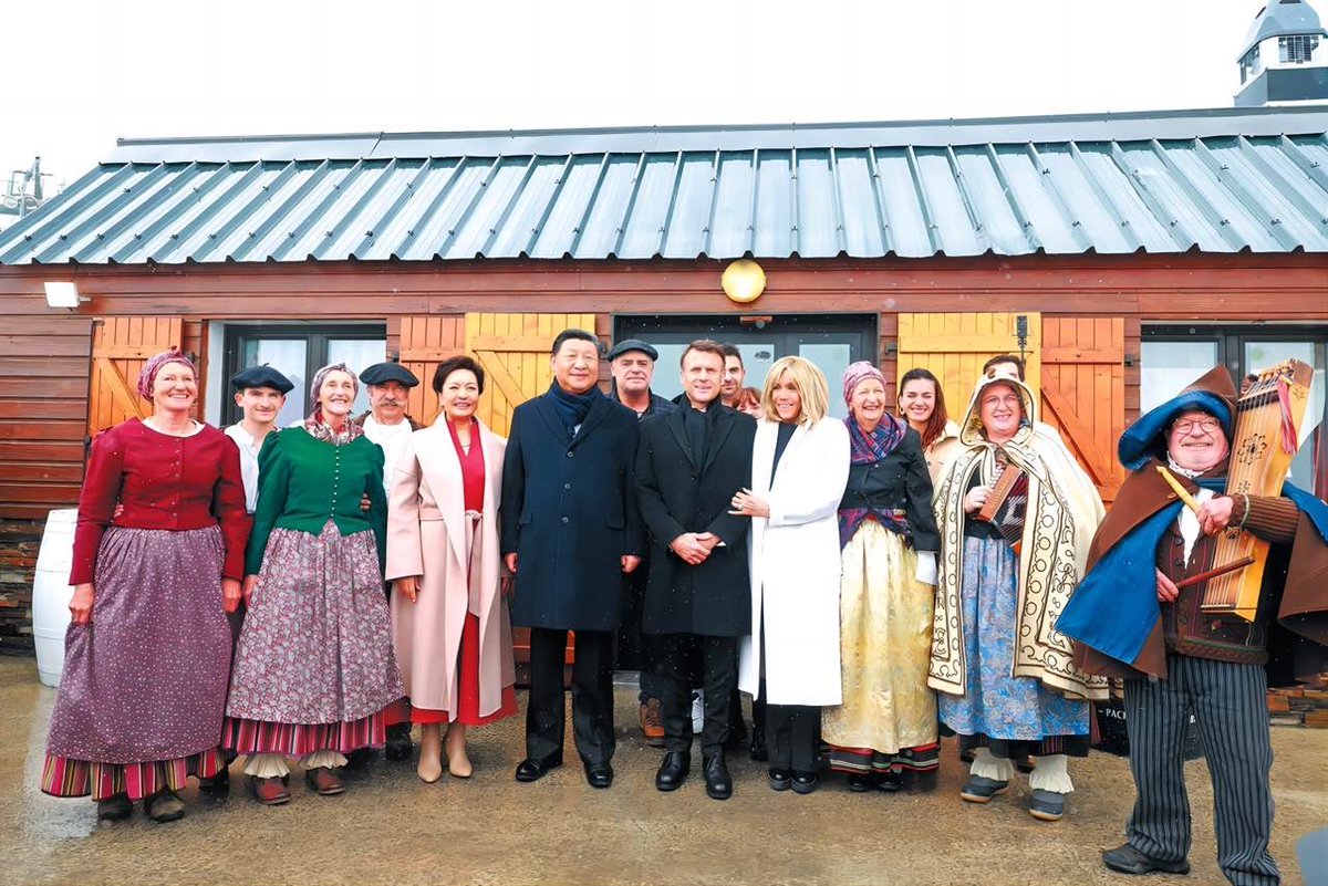 President Xi Jinping and his wife, Peng Liyuan, pose for a photo on Tuesday with French President Emmanuel Macron and his wife, Brigitte Macron, as well as local residents, after a welcoming performance at Col du Tourmalet in southwestern France.
