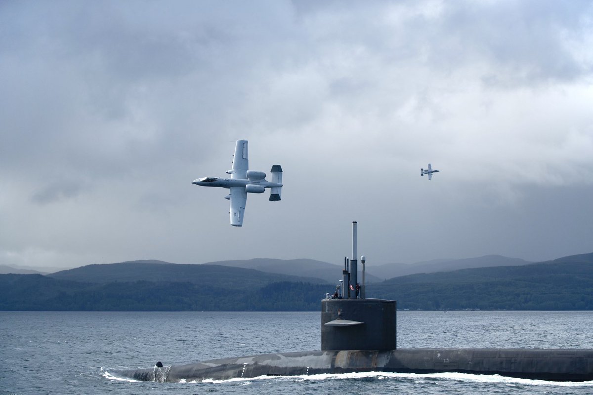 sentdefender's tweet photo. Awesome Images from yesterday showing a Squadron of A-10 Thunderbolt II “Warthog” Close-Air Support Aircraft being used to Escort the Ohio-Class Nuclear Ballistic Missile Submarine, USS Nebraska (SSBN-739) through the Strait of Juan de Fuca from Naval Base Kitsap in Northwestern Washington towards the Pacific Ocean.
