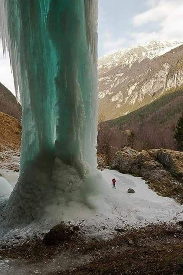 Amazing frozen waterfall in the Alps, Italy. Human for scale 💧❄️