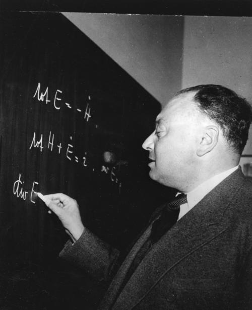 Wolfgang Pauli writing on blackboard at the time of his induction as a foreign member of the Royal Society, April 1953. Can you guess what he is writing on the chalkboard? ✍️ 📷 Keystone Photopress