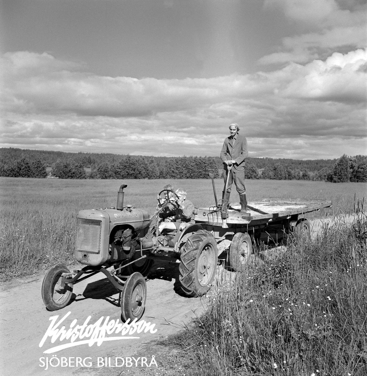 Klart pojkarna ska köra traktor. Året är 1949 och i Dala-Floda rullar traktorn förbi fotografen med barnen vid ratten. Pappa står på vagnsflaket.
Den ska börjas i tid...

#landsbygd #barn #traktor #barndom #Sverige