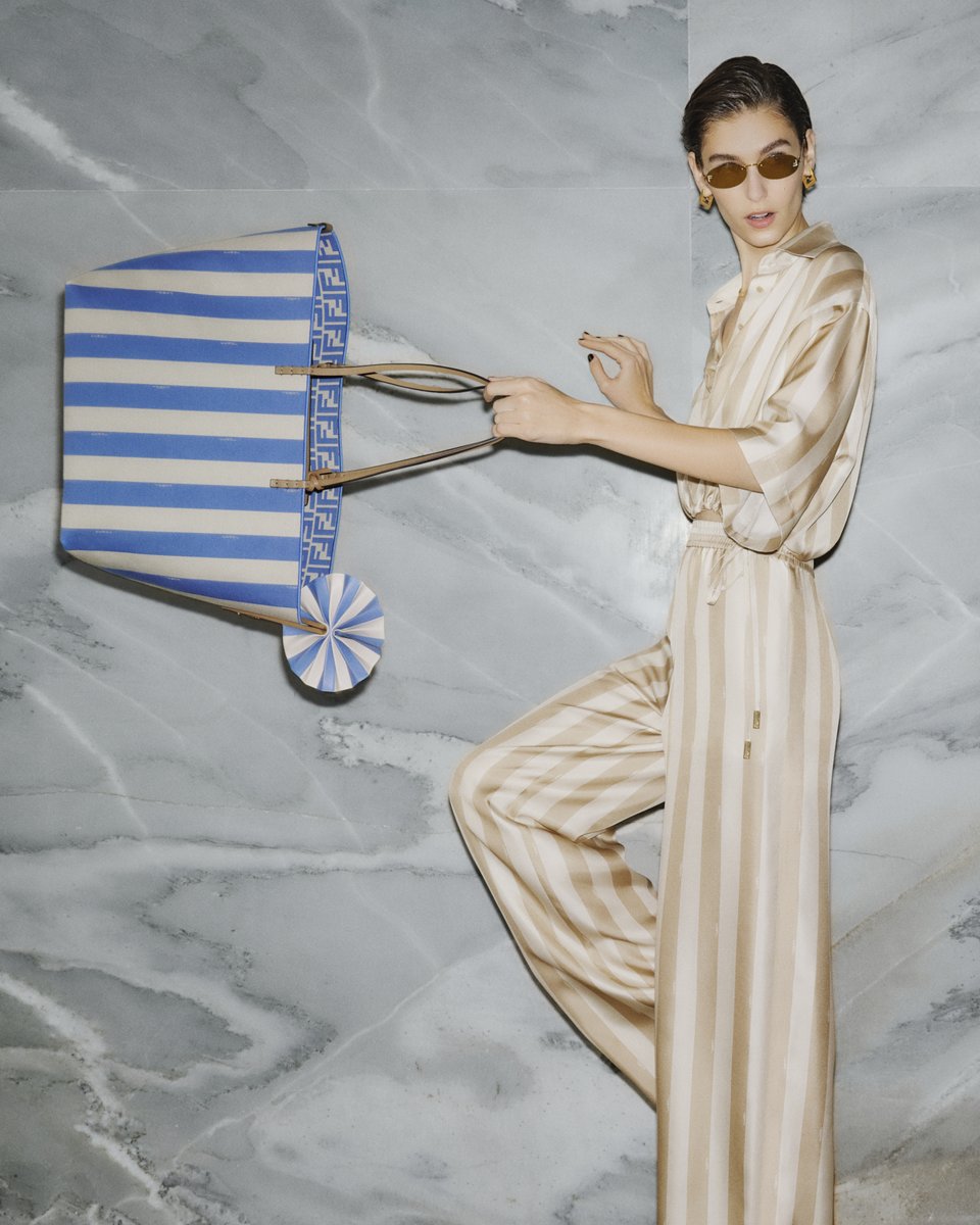 A reversible tote with two classic motifs – the Pequin stripe and the FF. Created by Silvia Venturini Fendi in 1997, the Roll bag has been plucked from the archive and reimagined through the allure of Rome's dolce vita for #FendiSummer to pair with the collection's…