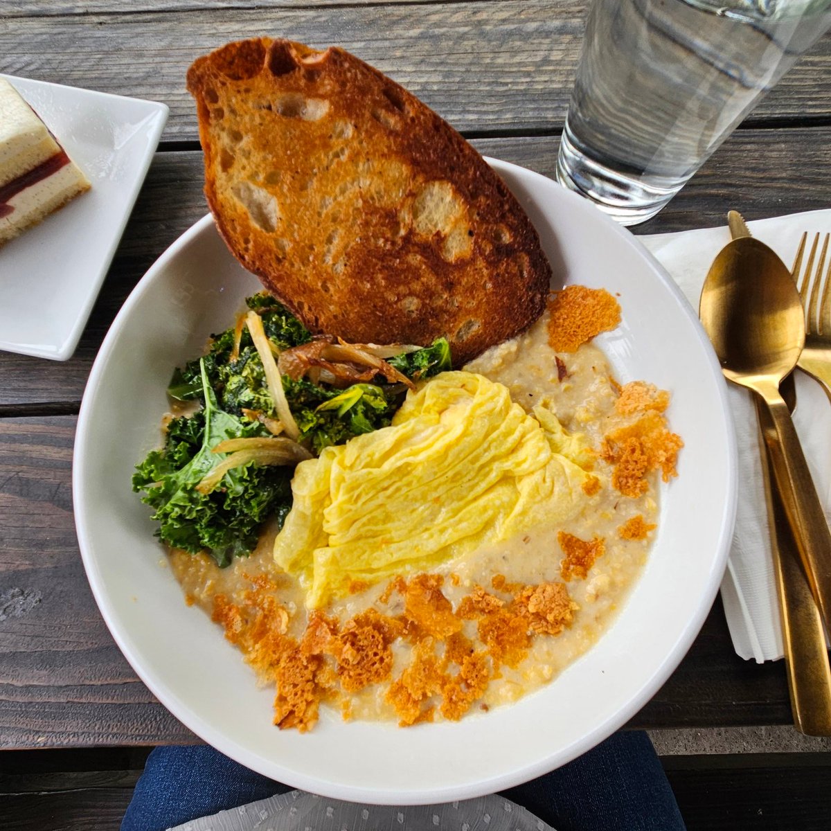 Was picking up a loaf of bread, it's close to lunchtime, & sometimes you just have to treat yourself to a nice hearty brunch. Grits with sauteed kale, caramelized onions, scrambled eggs, buttered toast & pan toasted cheese flakes. Loved it! 
West End Bakery in West Asheville.