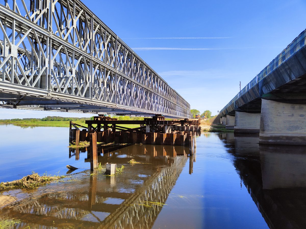 GDDKiA_B_stok's tweet image. Trwa montaż konstrukcji mostu tymczasowego przez Narew w rej. Wizny oraz budowa drogi objazdowej. Po przełożeniu na nią ruchu (poł. czerwca) stara przeprawa na #DK64 zostanie rozebrana. W jej miejscu powstanie nowy obiekt – ma być gotowy w IV kw. 2025 r.