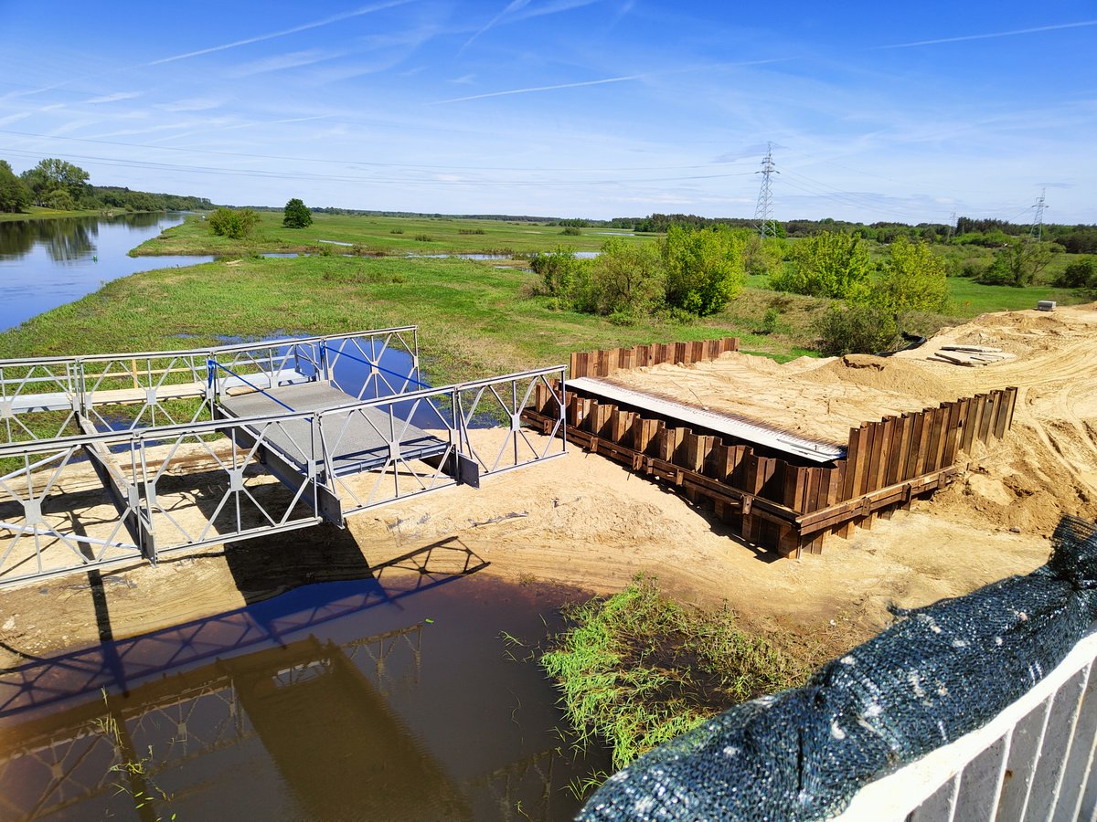 GDDKiA_B_stok's tweet image. Trwa montaż konstrukcji mostu tymczasowego przez Narew w rej. Wizny oraz budowa drogi objazdowej. Po przełożeniu na nią ruchu (poł. czerwca) stara przeprawa na #DK64 zostanie rozebrana. W jej miejscu powstanie nowy obiekt – ma być gotowy w IV kw. 2025 r.