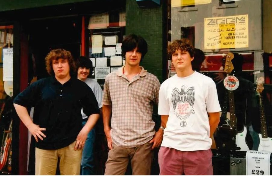 John Squire and some fans outside a guitar shop in 1997