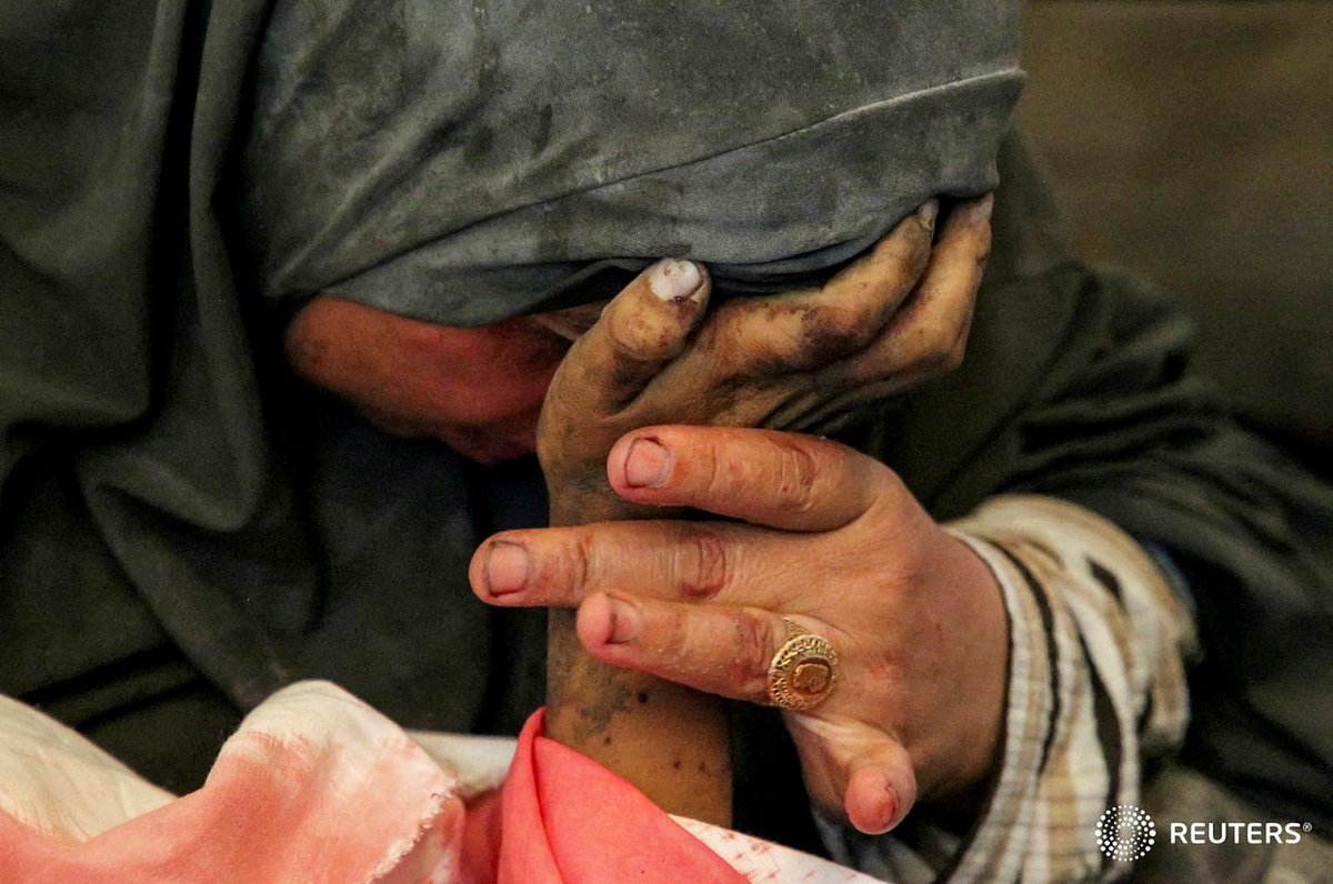 Palestinian woman Buthayna Abu Jazar reacts as she holds the hand of her son Hazma, who was killed in an Israeli strike, amid the ongoing conflict between Israel and Hamas, in Rafah, in the southern Gaza Strip May 9, 2024. REUTERS/Hatem Khaled