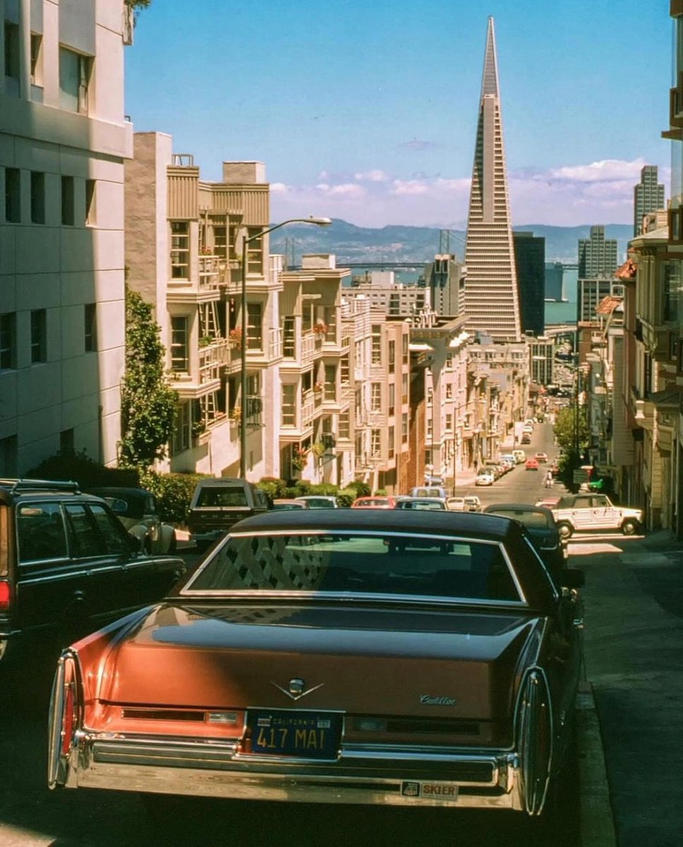 USA 🇺🇸 San Francisco, Rétro cars voiture 🚘 la Cadillac Coupe orange de 1974-76 à Jones & Clay au loin le Transamerica Building (1978)
