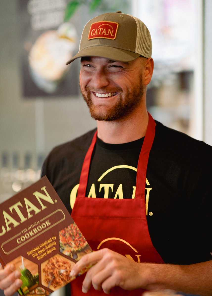 HECK YEAH! 😎 It's time to set-tle the table with the official CATAN Cookbook and Apron! 👩‍🍳 bit.ly/3PijkqQ 👨‍🍳 #catan #settlersofcatan #cookbook