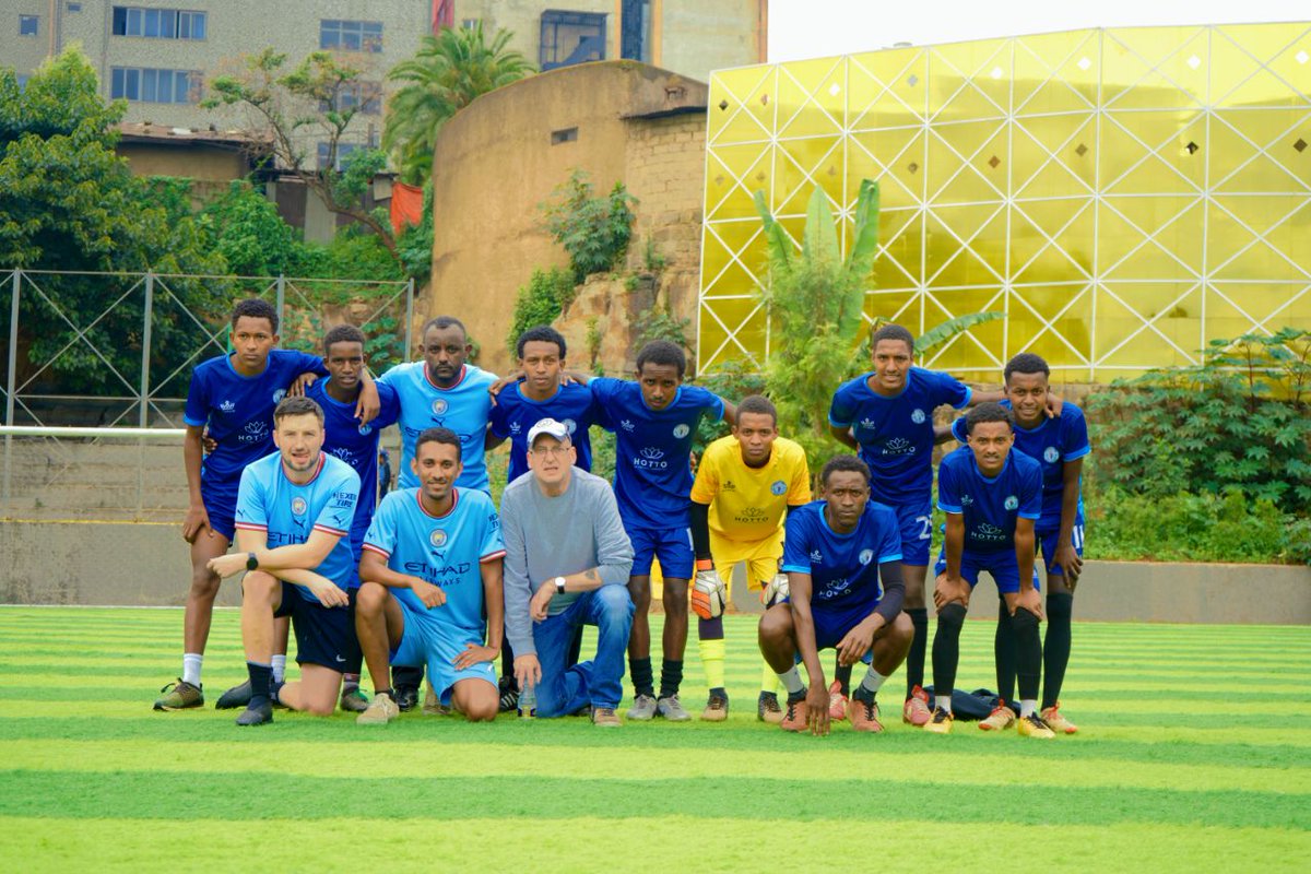 ManCityAddis2's tweet photo. While visiting, we exchanged city tales and enjoyed laughs. Our guests savored injera and doro wat, and together, while we cheered for the Blues during a thrilling match. They also played in a spirited match with our academy youths, displaying their love for football. https://t.co/KPMLl5Zdd8