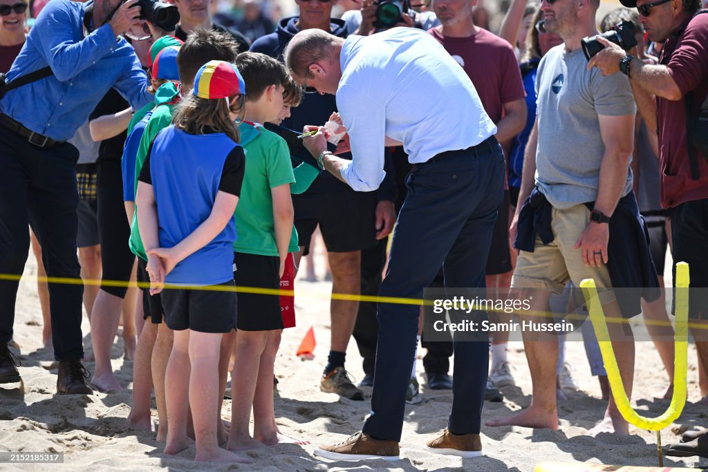 MAY 09: Prince William, Prince of Wales signs a child's plaster cast on Fistral Beach , #PrinceOfWales #HRHDukeOfCornwall He signed a little boys Cast