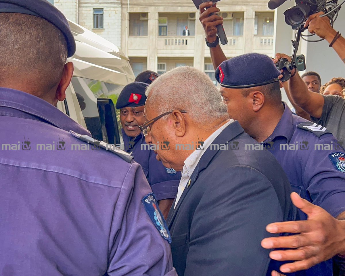 Former PM Bainimarama being escorted to the waiting transport that whisked him to the Korovou Correctional Facility after he was sentenced to 1 year in prison. He is clearly seen here to have covered his handcuffed wrists while former Police Commissioner Sitiveni Qiliho was…