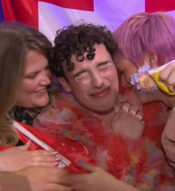 🟨⏹️🟪⬛️ Im Moment der Entscheidung zeigt Nemo Flagge: Nicht das 🇨🇭Schweizerkreuz, sondern die Nonbinary-Flagge.  

Die Symbolik hinter den Farben:
- 🟨 Gelb steht für die Verortung ausserhalb des binären Geschlechtersystems.
- ⏹️Weiss steht für Menschen, die sich mit mehreren