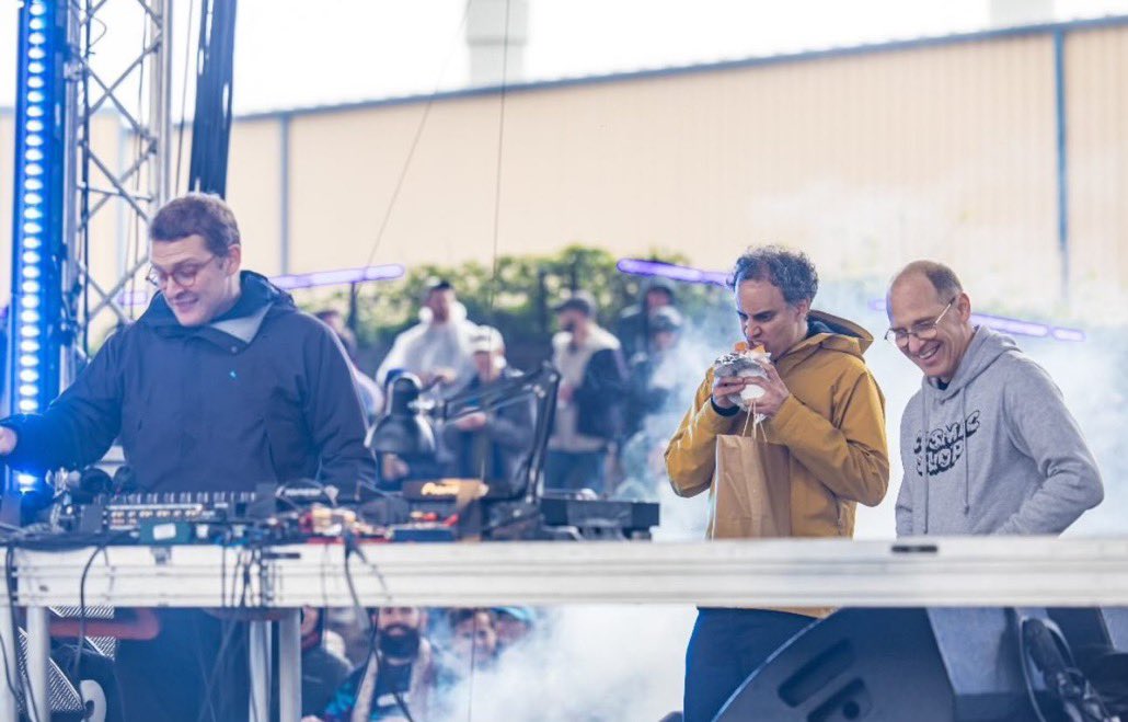 four tet stuns in new photo, eating what appears to be a burrito, on stage