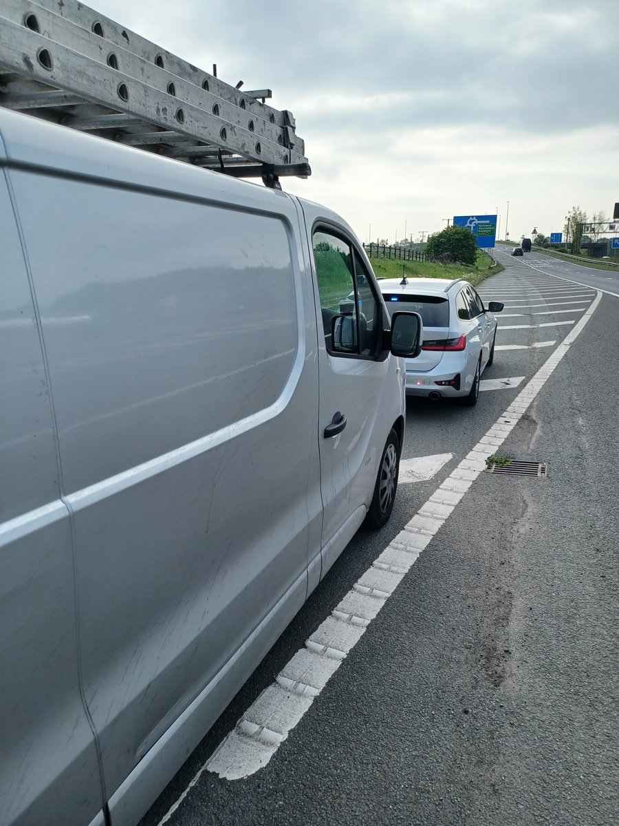Male Driving holding a mobile phone in his left hand up to his left ear whilst steering with a cigarette in his right hand. 

M6 South J19.

Reported for mobile phone and failing to wear his seatbelt which was wrapped around the rear of his seat.
