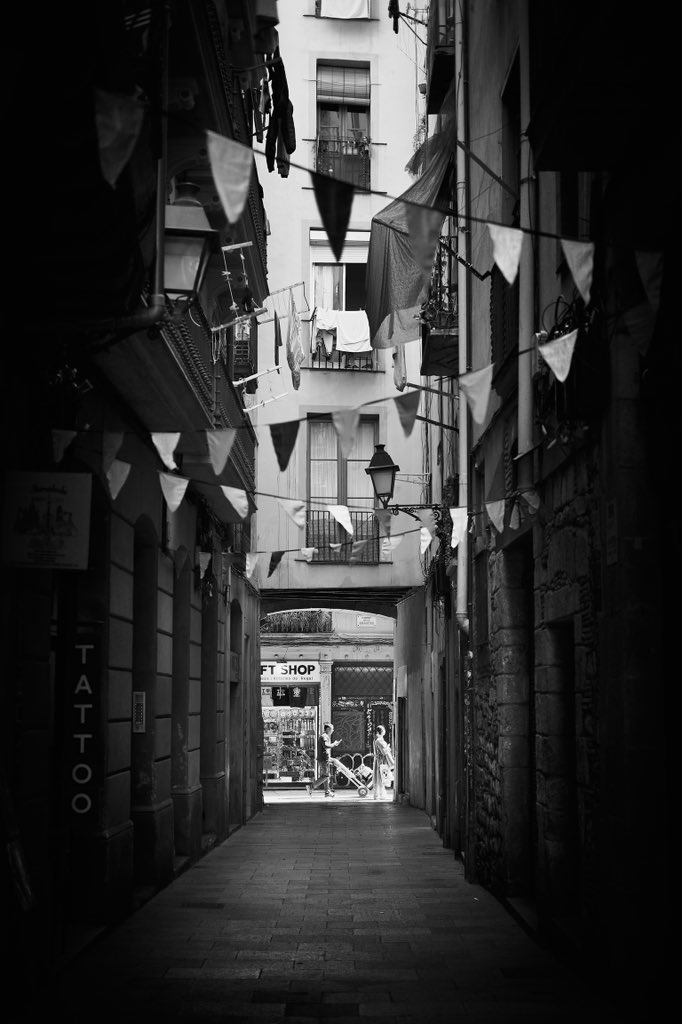 Festively decorated alley 📸 Fujifilm X-T4 📷 Fujinon XF 35mm F2 R WR ⚙️ ISO 160 - f/2.0 - Shutter 1/500 📍 Carrer de Sant Jacint, Sant Pere, Santa Caterina i la Ribera, Ciutat Vella, Barcelona #StreetPhotography #BlackAndWhite