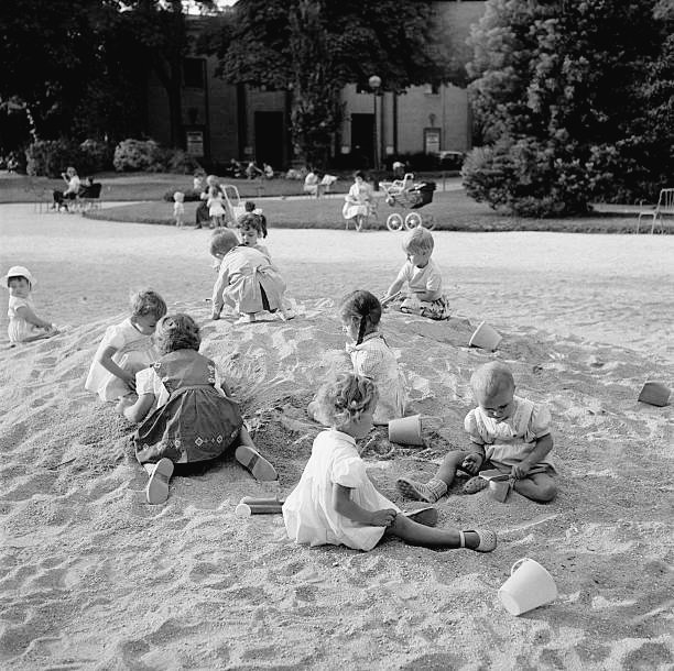 Keystone-France. Fillettes jouant dans le bac à sable, avenue des Champs-Élysées, sous le regard de leurs mamans 1959. Paris