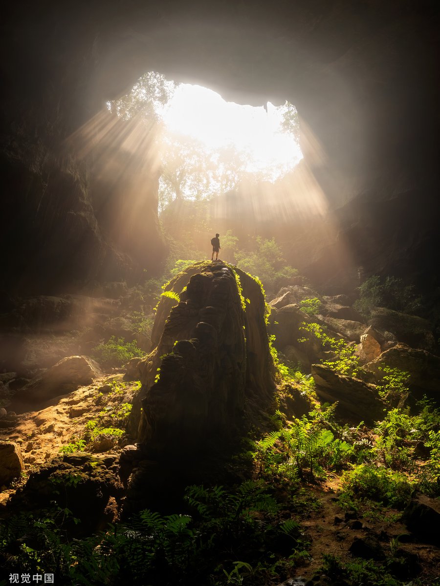 Sunshine casts into a karst sinkhole in Hechi, south China's Guangxi Zhuang Autonomous Region, attracting many visitors. @DiscoverGuangxi @Splendors_of_GX