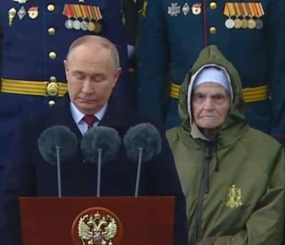 Who's standing by Putin? Looks like Death. By the way, there are two murderers from Bucha behind them.