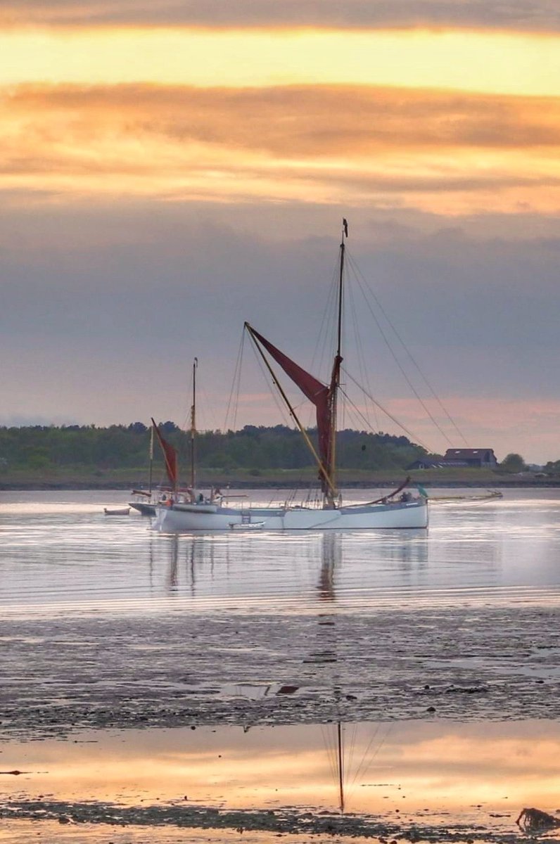 Barge home over the river colne in Brightlingsea at sunset .
