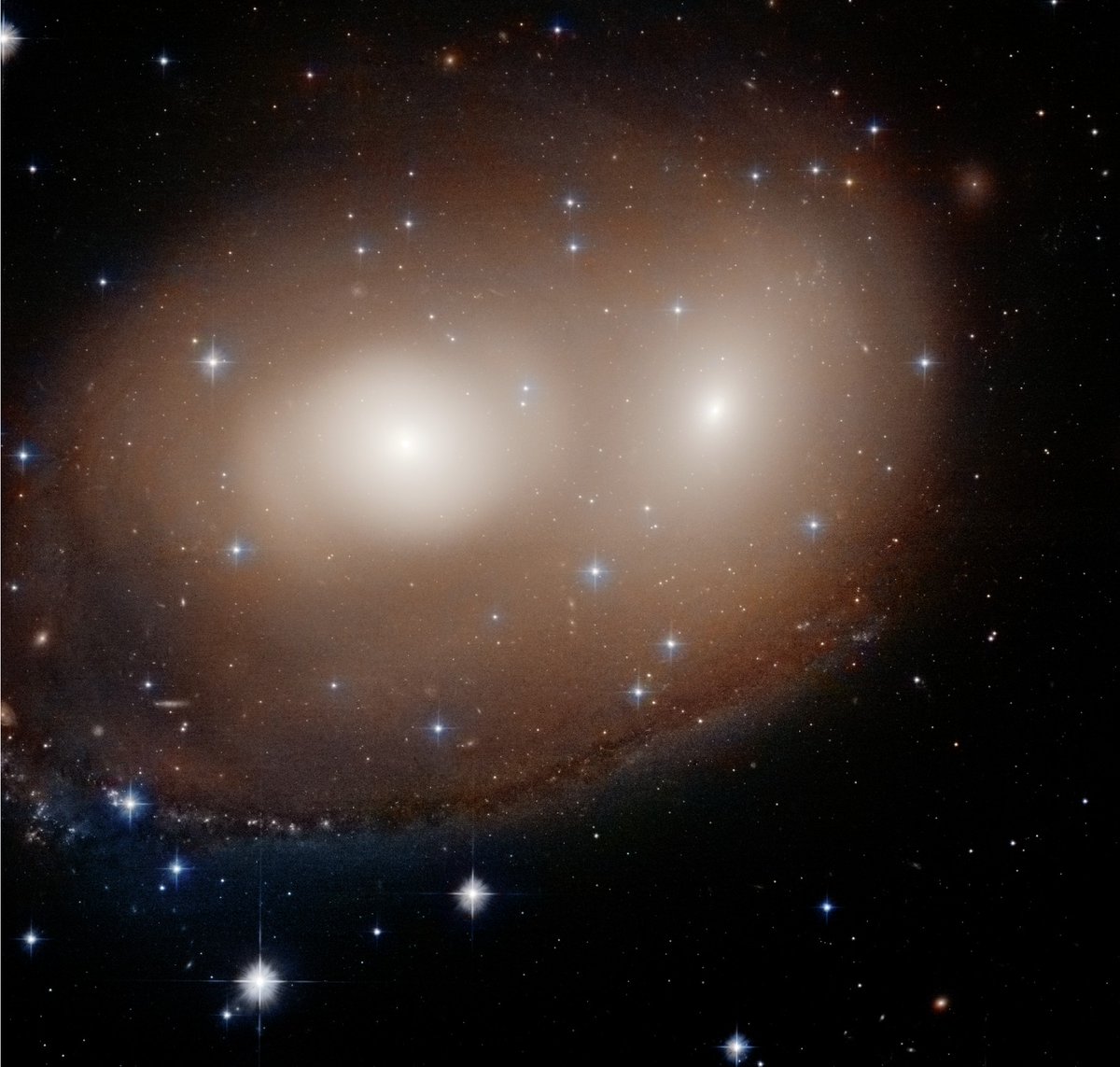 This pair of galaxies, NGC 2292 and NGC 2293, is beginning to collide, which has started the formation of new stars. These new stars appear like blue pearls in the dusty arm along the bottom. Discover more about their interaction: bit.ly/3TK5wru