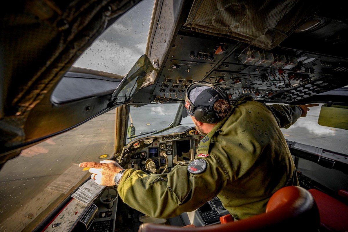 RCAFOperations's tweet photo. A Flight Engineer in the cockpit of a @RCAF_ARC CP-140 Aurora communicates with techs on the ground via hand signal during a pre-flight inspection. The #RCAF CP-140 Detachment is deployed to Iceland for #NATO’s Exercise #DYNAMICMONGOOSE. #WeAreNATO https://t.co/3vjnpTK3Yj