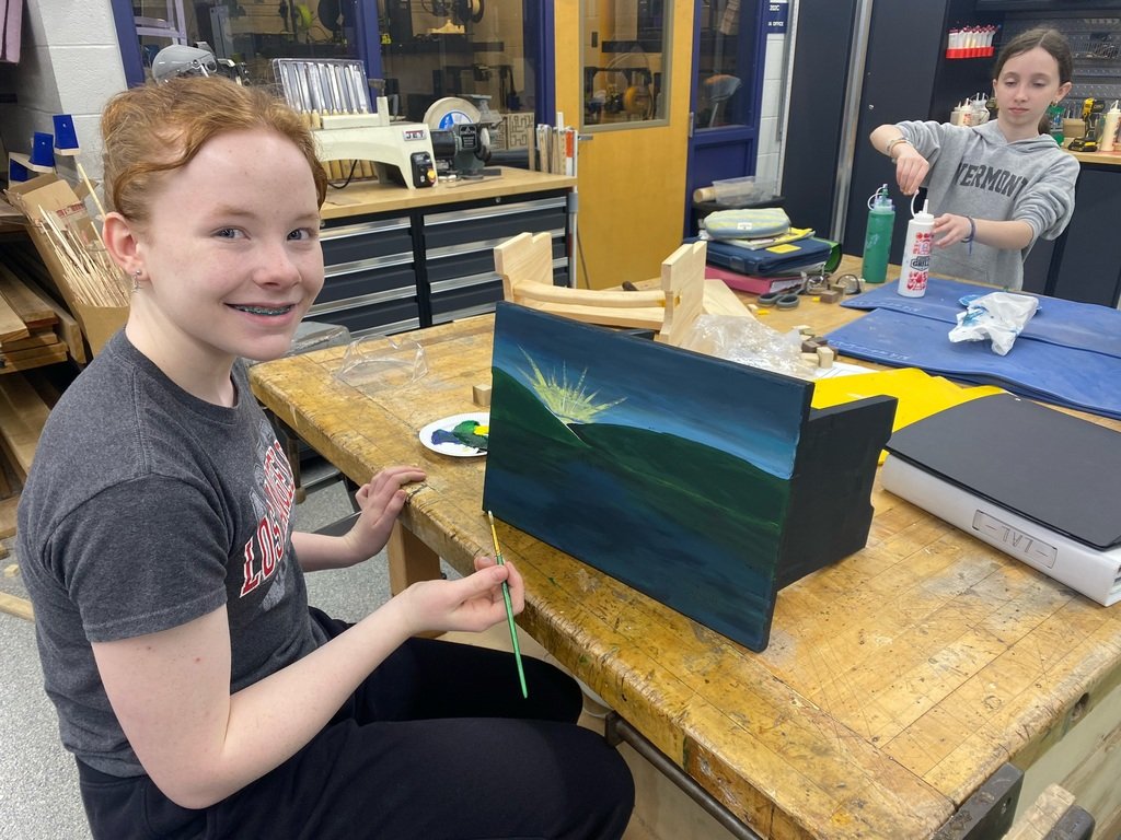 Woodworking for the 21st-century student, taking the time to add a landscape painting to the top of her completed stool. #mendhamboroschools #lionspride