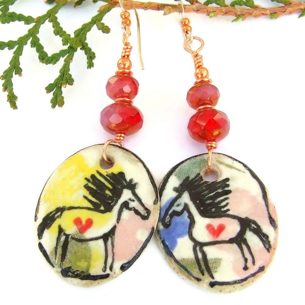 Hand painted ceramic horses & hearts earrings w/ faceted cranberry glass: perfect handmade gift for the horse lover w/ a boho vibe! buff.ly/3vonzuG via @ShadowDogDesign #ejwtt #HorseLover #HorseEarrings