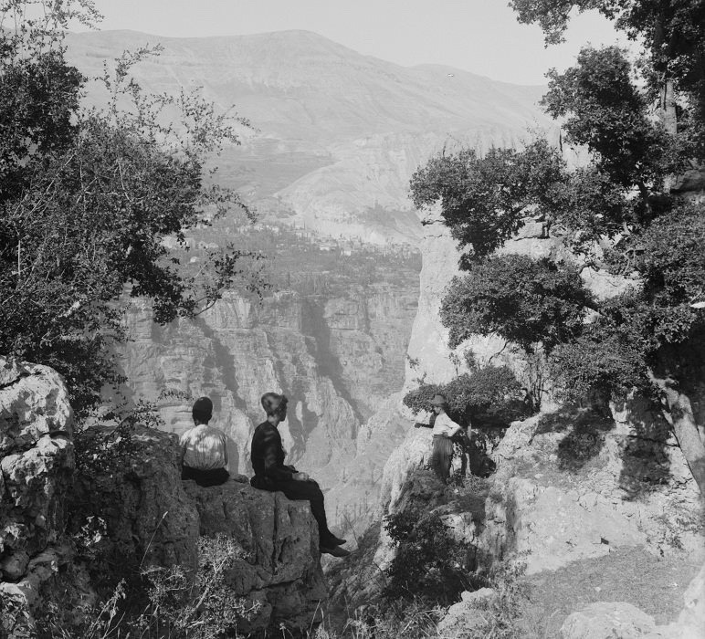 Two villagers sat on a boulder facing the Qadisha Valley, Lebanon, 1920s. 🇱🇧
