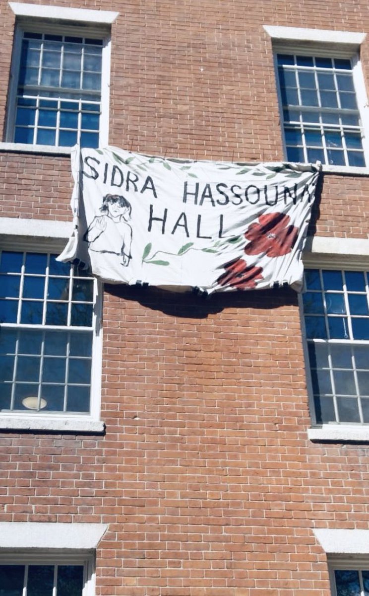 Many of us saw, and can never unsee, the uncensored photo of the little girl hanging on the wall, her body shredded by Israeli bombs. #Harvard students have renamed this building in her honour. Her name was Sidra Hassounn. She was 12 years old. Never forget.