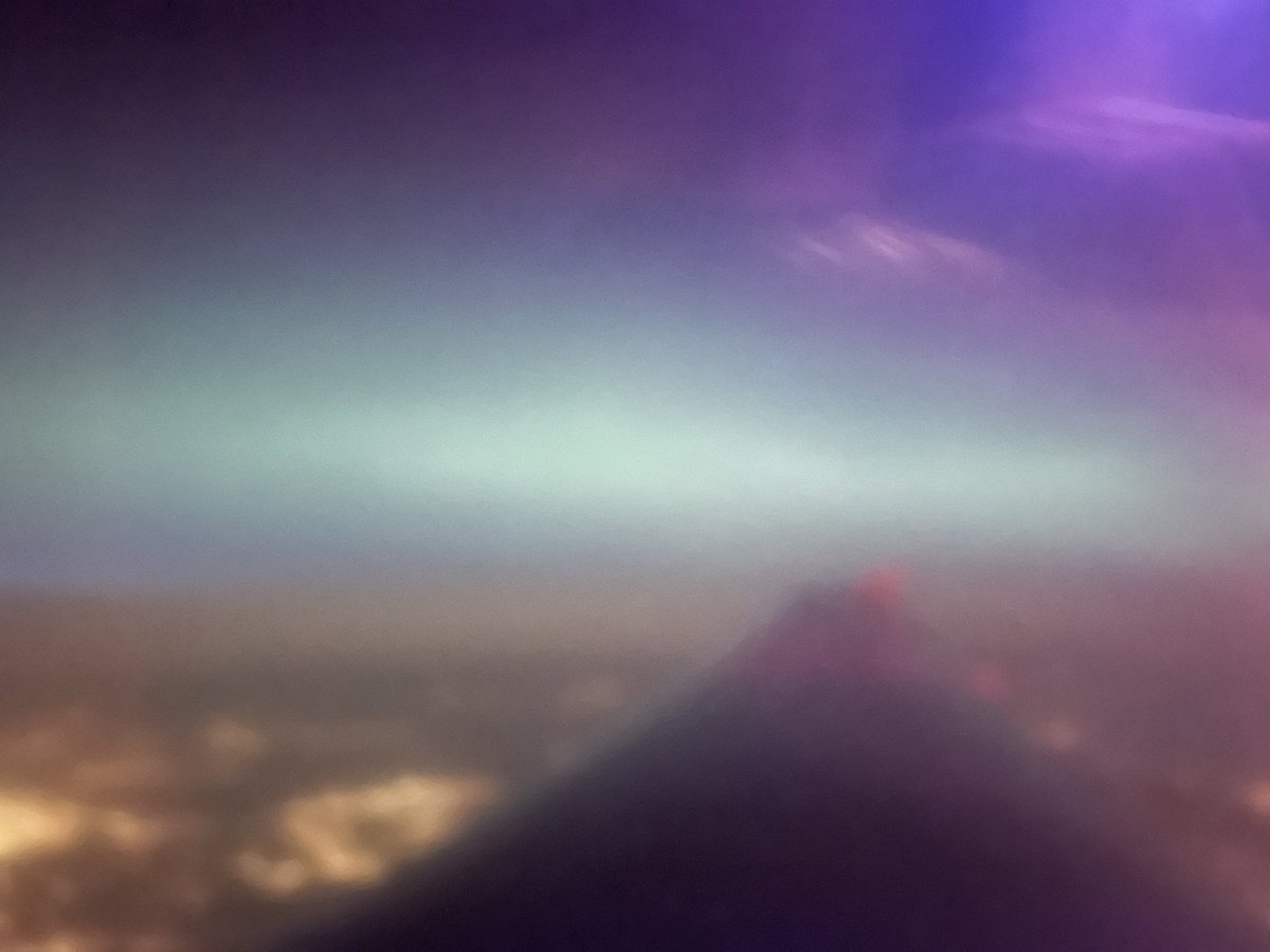Dr_Lucie's tweet photo. From my flight home (after a conference to discuss the science of solar eruptions!). I won’t win any awards for my photography, but I was delighted to see it even though it was off in the distance from my perspective #Auroraborealis https://t.co/mKvgaHZ6nB