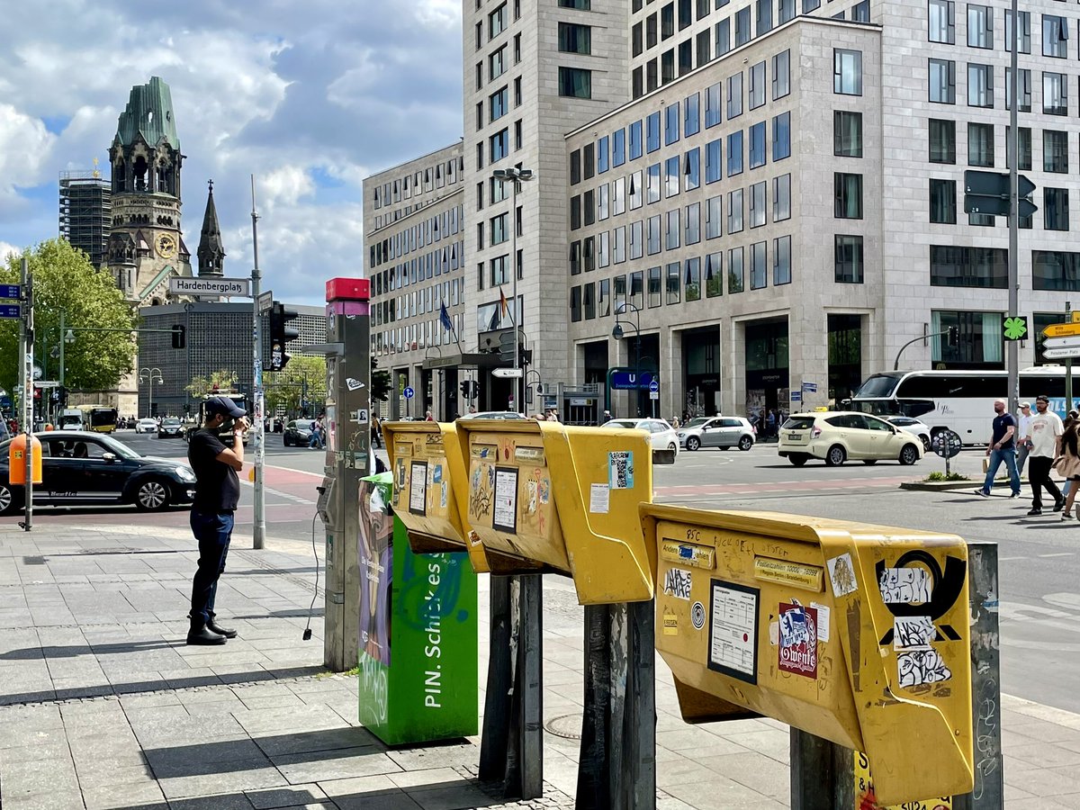 Three postboxes in a row outside Zoologischer Garten railway station in Berlin 🇩🇪. In the background is the Kaiser Wilhelm Memorial Church, bombed in WW2, around which a modern cathedral was built in a similar way to Coventry 🇬🇧. #postboxsaturday