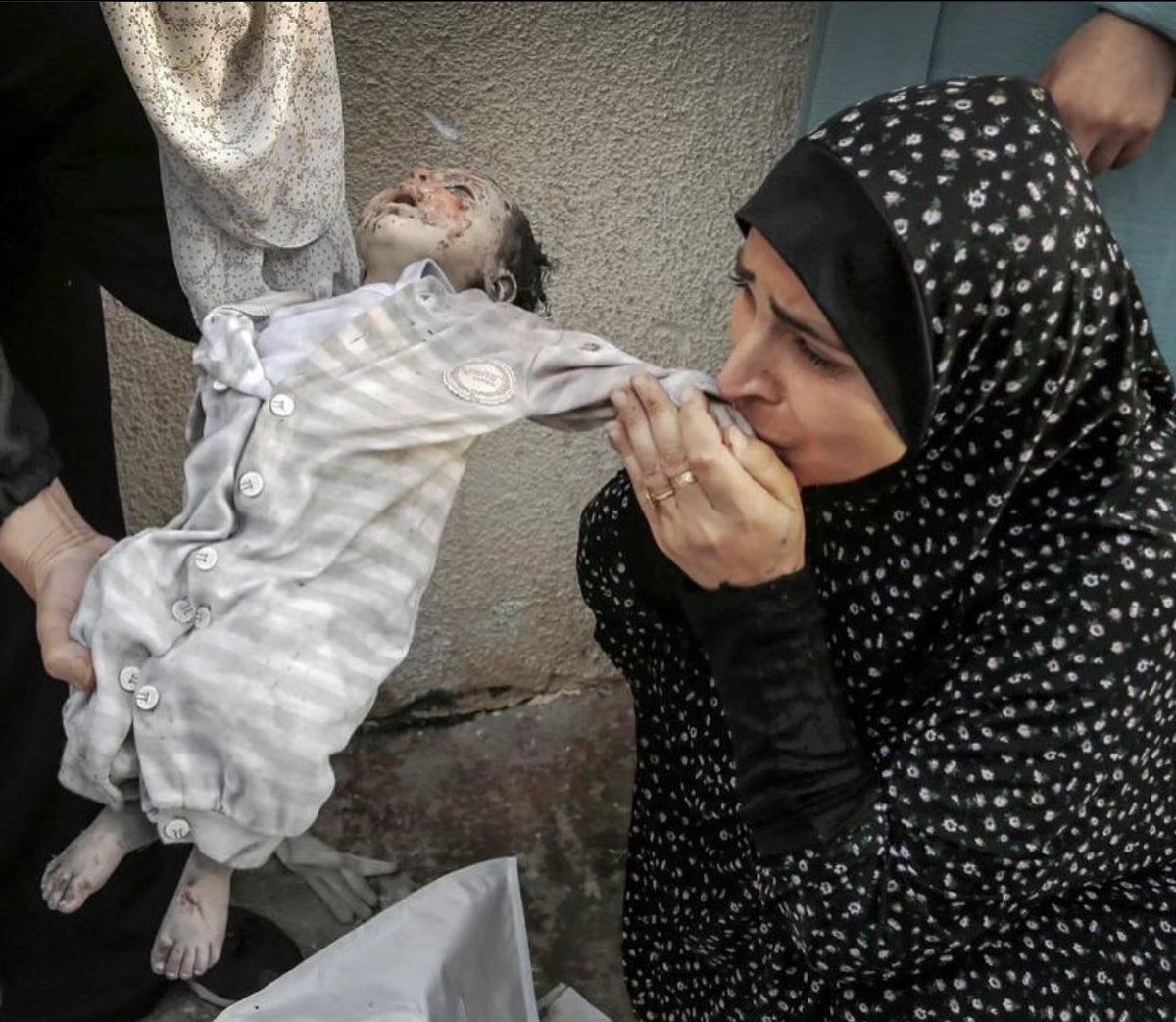 A mother bids farewell to her baby who was killed along with her other children by an Israeli bombardment in Gaza.
