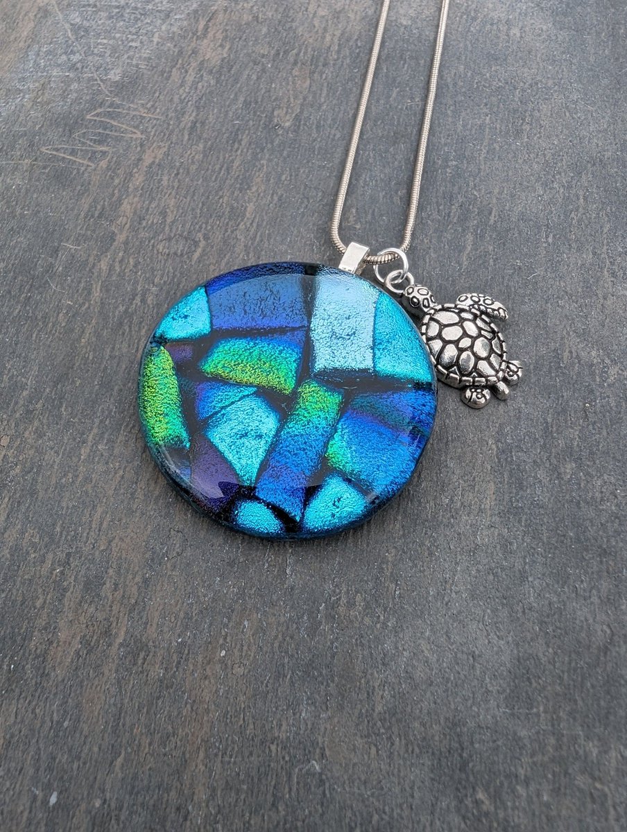 Beautiful sparkling blues, green and purples in this handcrafted dichroic glass necklace. Comes with a sweet turtle charm. #ukgiftam #ukgifthour #handmade #etsy #giftideas #shopindie #etsyuk buff.ly/3WzPzY6
