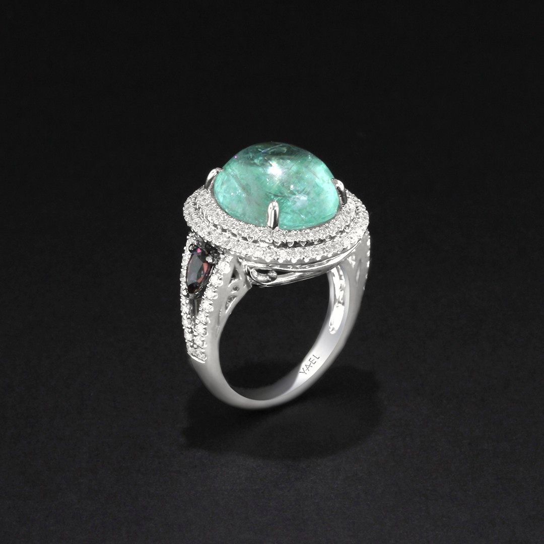 A 9.54ct Paraiba Tourmaline Cabochon takes center stage, adorned by the mesmerizing hues of color-change Garnet and the brilliance of diamonds. A masterpiece that radiates sophistication and timeless beauty. ✨️#YaelDesigns #WhatsYourColor