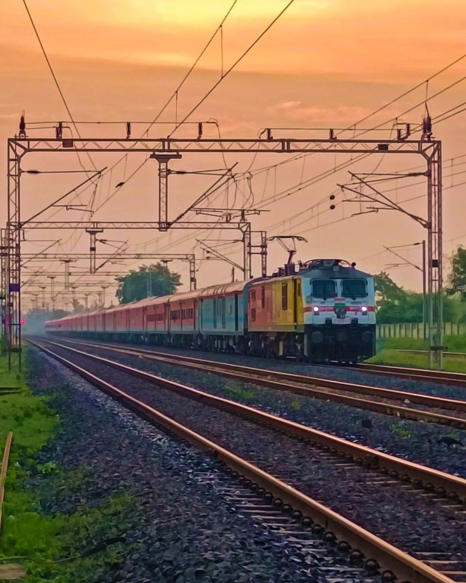 Bidding adieu to the amber sky, a train graces forward on its way towards Kansudhi Railway Station, Gujarat. #SweetScenesonSaturday