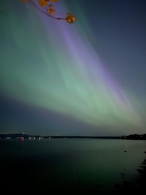 Northern lights over large body of water