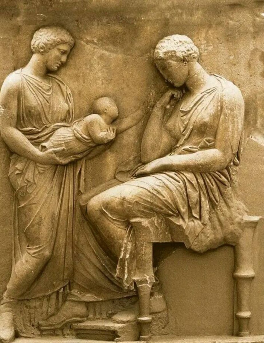The mother looks longingly at her baby. The baby wants to touch its mother, who has passed into another realm, but cannot. The baby is sad in the arms of another woman and the mother is in grief. Archaeological Museum in Athens.