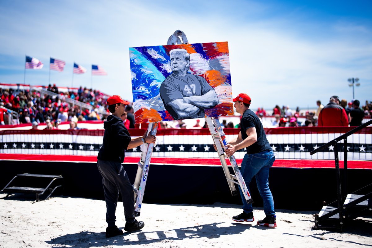 Workers carry away a painting of @realDonaldTrump after artist Scott LoBaido did a live painting on stage ahead of a Trump campaign rally in Wildwood, N.J.