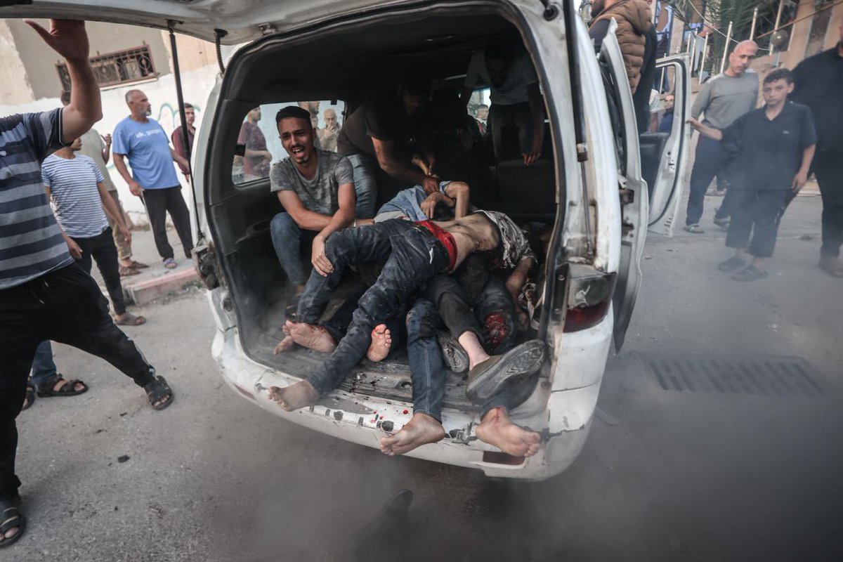 Six people were killed as a result of an attack on a house in the city of Deir al-Balah, relatives mourned by the bodies of the dead in the streets. In shock, civilians tried to transport some severely injured individuals to the hospital. (Photo by Ali Jadallah/Anadolu)