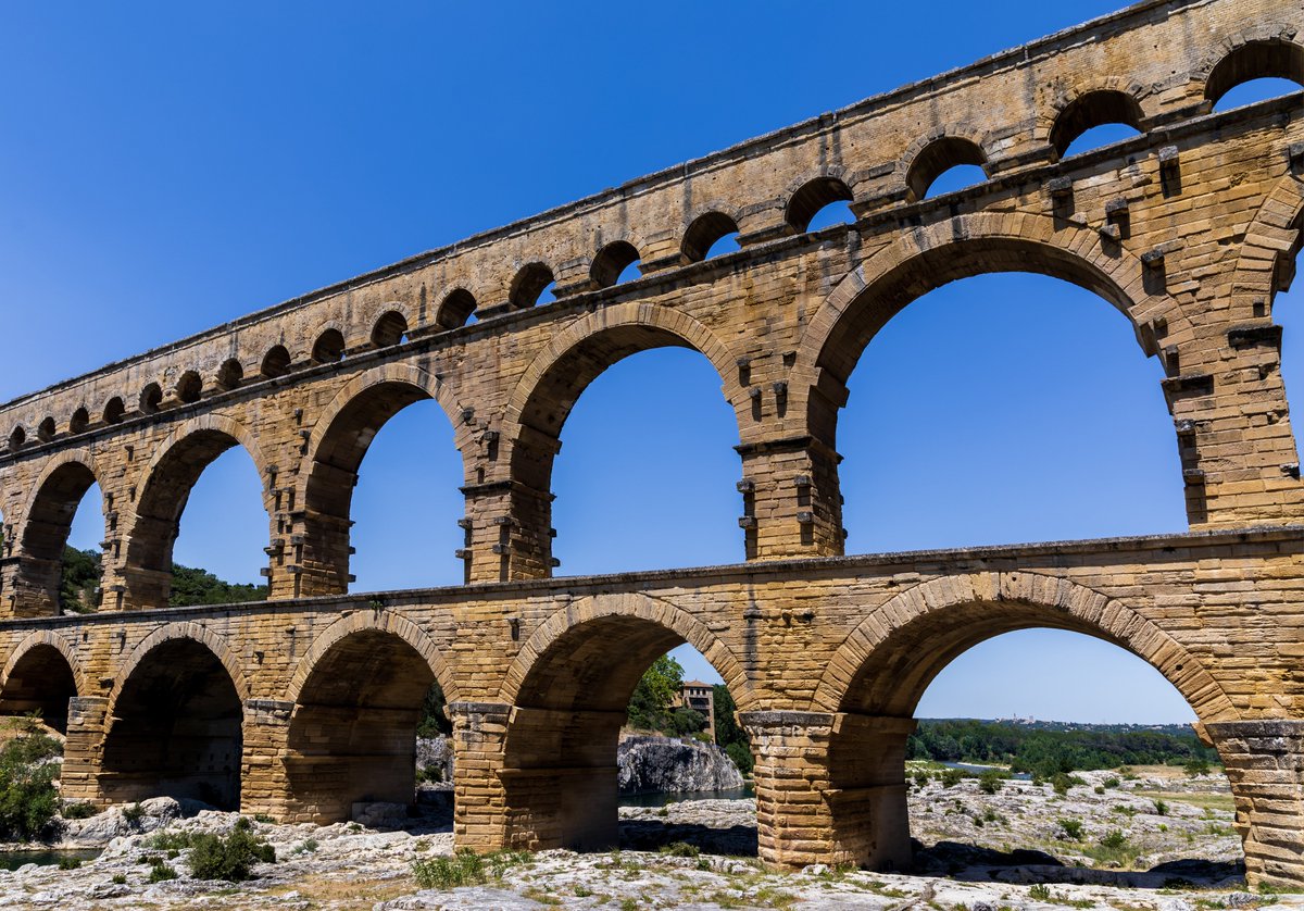 The Pont du Gard
The Pont du Gard stands as a testament to the ingenuity of ancient Roman engineering. Constructed around 19 BCE, this colossal aqueduct bridge was designed to carry water across the Gardon River to the Roman colony of Nemausus, now known as Nîmes. Conceived by