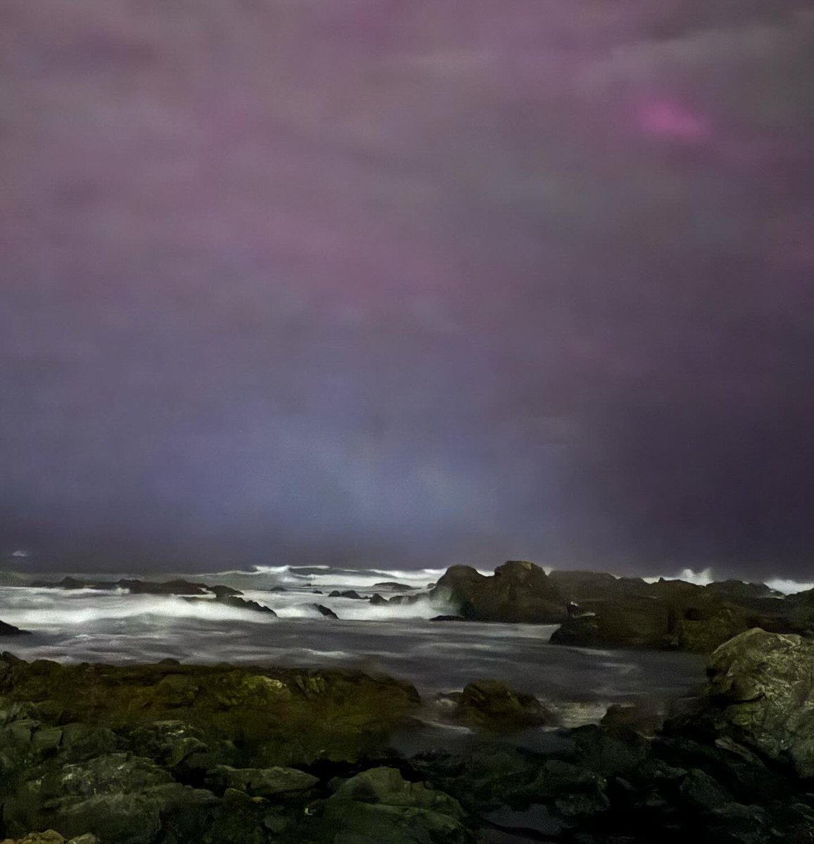 BritMumInNZ's tweet photo. It was cloudy by the time I went to look at the #auroraaustralis on Wellington’s south coast last night, but it was still beautiful to see dancing light beaming through the clouds and sea mist. The air was charged with sea spray and excitement. https://t.co/BtTKtl5P0A
