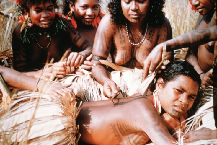 Motuan female tattooing the back of a young woman in Manu Manu, Papua New Guinea. Photo by Percy Cochrane, 1907-1980