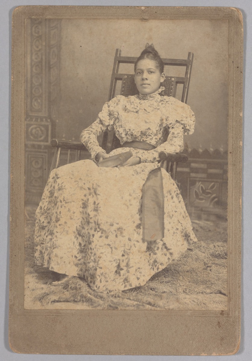 Photograph of a woman sitting in a chair, holding a book nmaahc.si.edu/object/nmaahc_…